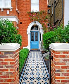 a blue door is in between two red brick buildings with white trim on the doors