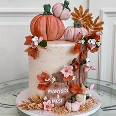 a wedding cake decorated with pumpkins and flowers