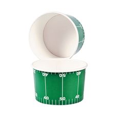 a green and white football field paper cupcake wrapper is shown with the lid open