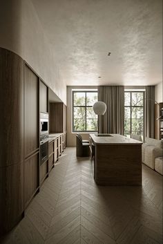 an empty kitchen with wooden cabinets and flooring in the middle, next to a large window