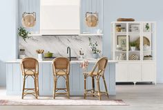 an image of a kitchen setting with blue and white decor on the countertops, chairs and cabinets