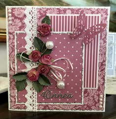 a close up of a card with flowers and pearls on the front, in pink