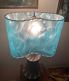 a blue glass lamp sitting on top of a wooden table