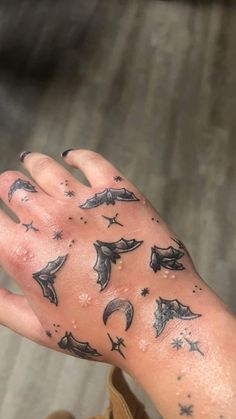 a person's hand with black ink on it and flying bats all over the palm