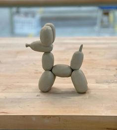 a small toy dog sitting on top of a wooden table