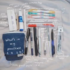 an assortment of pens and pencils laid out on top of a white sheet with words written all over it