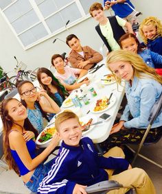 a group of people sitting around a table eating food