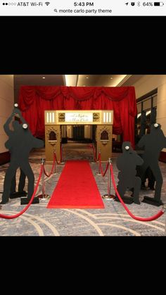 a red carpeted area with two black statues on it