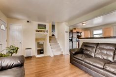 a living room filled with furniture next to a kitchen