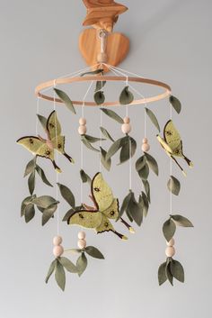 a mobile with green leaves and butterflies hanging from it