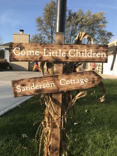 a wooden sign sitting on top of a lush green field