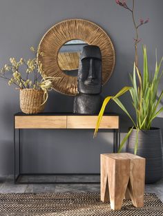 a wooden table topped with plants next to a mirror and potted plant on top of it