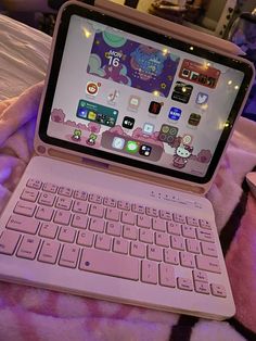 an open laptop computer sitting on top of a pink blanket next to a mouse and keyboard