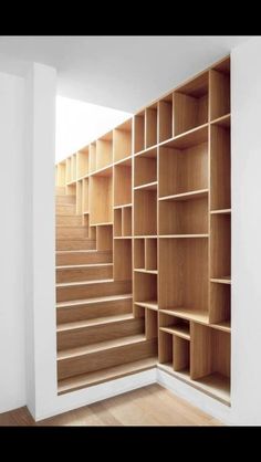 an empty room with wooden shelves and stairs