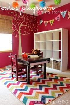 a child's playroom with pink walls and colorful rugs