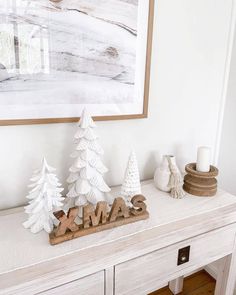 a white table topped with wooden christmas trees