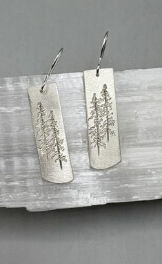 Large sterling silver Tall Pine Earrings etched with Lodge Pole Pines. The earrings dangle from sterling silver French wires and measure 1 1/8" x 3/8". Nature-inspired Sterling Silver Etched Jewelry, Nature-inspired Etched Sterling Silver Jewelry, Etched Silver Nature-inspired Jewelry, Etched Nature-inspired Silver Jewelry, Nature-inspired Etched Silver Jewelry, Silver Etched Earrings As A Gift, Engraved Sterling Silver Dangle Earrings, Silver Etched Earrings For Gifts, Engraved Silver Earrings As Gift