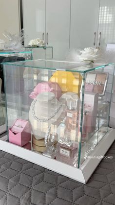 a display case filled with lots of different types of perfumes and jewelry on top of a bed