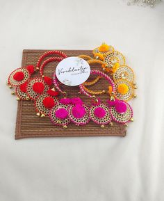 USE LATKAN HANGING BANGLES AS PART OF THE WEDDING FAVOR, SANGEET CEREMONY & FESTIVAL GIFTING Product Contains * Product:- 1 x Hanging Bangle  Product Details * Product Name:- Hanging Bangle * Material: Metal & Pompom Product Usage * Delight your guests with pompoms latkan hanging bangles as wedding favors. These colorful and fun accessories will serve as a memorable keepsake from your special day * Use pompoms latkan hanging bangles as giveaways at the sangeet ceremony. These bangles will be a h Silk Thread Bangle Bracelets For Festivals, Festive Silk Thread Bangle Jewelry, Festive Silk Thread Bangle Bracelet, Festive Gold Silk Thread Bangle, Gold Silk Thread Bangle Jewelry, Traditional Silk Thread Bangle Bracelets, Gold Silk Thread Bangle, Diwali Silk Thread Bangle Bracelets, Diwali Silk Thread Bangle Jewelry