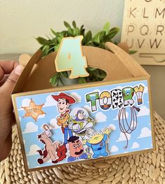 a person holding up a toy story card in front of a basket filled with toys