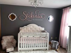 a baby's room with a white crib and pink accents