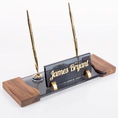 a pen holder with two pens on top of it and a wooden plaque that says james bright