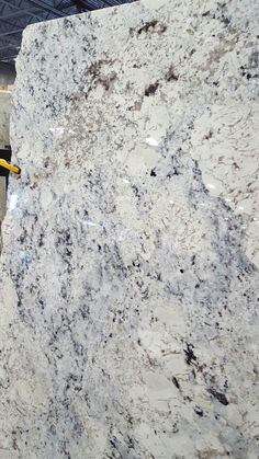 a marble slab is being worked on by a man with a yellow safety harness in front of it