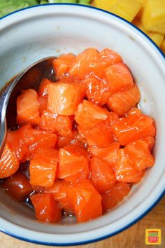 a bowl filled with sliced up carrots next to a pile of cut up fruit