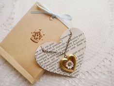 an open book with a heart pendant on it