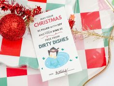 a christmas ornament sitting on top of a plate next to a red and white checkered table cloth