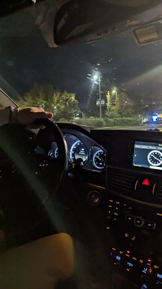 the interior of a car with dashboard lights on at night, and an electronic display in the passenger seat