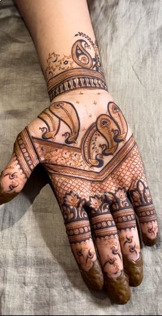 a woman's hand with henna tattoos on it