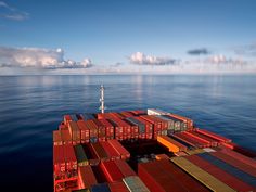 a large cargo ship in the middle of the ocean with containers stacked on it's deck