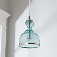 a blue glass light hanging from a ceiling