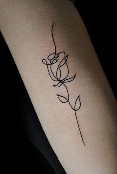 a small rose tattoo on the arm