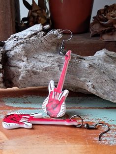 a pink guitar shaped keychain sitting on top of a wooden table