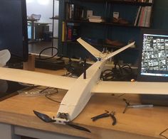 a model airplane sitting on top of a desk next to a computer monitor and keyboard