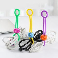 several different colored wires and cords in front of a laptop