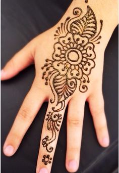 a woman's hand with henna tattoos on it