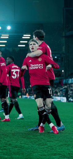 two soccer players are hugging each other on the field