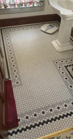 a bathroom with black and white tiles on the floor