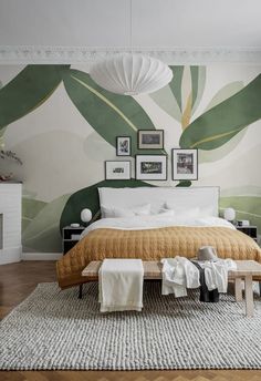 a large bed sitting in a bedroom next to a wall with pictures on it's side