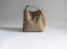 The perfect mid-size hobo bag to hold everything you need.  This canvas tote has lots of pockets to stay organized and is compact yet spacious with a casual shape that is easy to carry as a crossbody bag or shoulder bag.  This listing is for the MEDIUM size bag in Khaki Canvas. DETAILS: Approximately 10.5in H x 11in W x 2.5in D. Durable woven canvas exterior in Khaki canvas with a slightly faded finish. Two exterior front pockets. Magnetic snap closure at top center. Fully lined. Two interior sl Canvas Hobo Bag, Urban Chic Fashion, Canvas Crossbody Bag, Waxed Canvas, Urban Chic, Perfect Bag, Small Bag, Hobo Bag, Canvas Tote