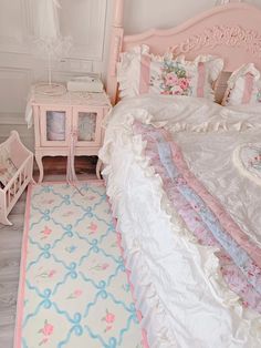 a pink and white bedroom with an ornately decorated bed, nightstands, and rug