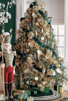 a christmas tree decorated with gold and green ribbons