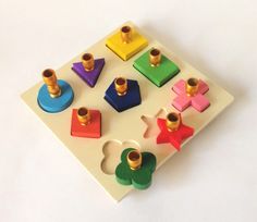 a close up of many different colored toys on a white surface with holes in the middle