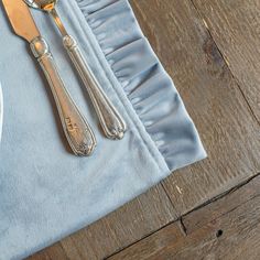 a plate with silverware on it next to a fork and spoon sitting on top of a blue napkin