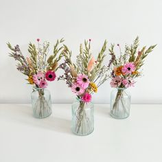 three vases filled with different types of flowers