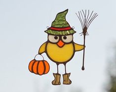 a yellow bird with a green hat holding a broom and a pumpkin hanging from it's tail