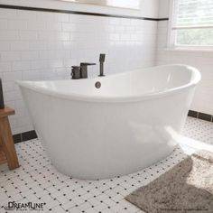 a white bath tub sitting in a bathroom next to a wooden stand with a mirror on it